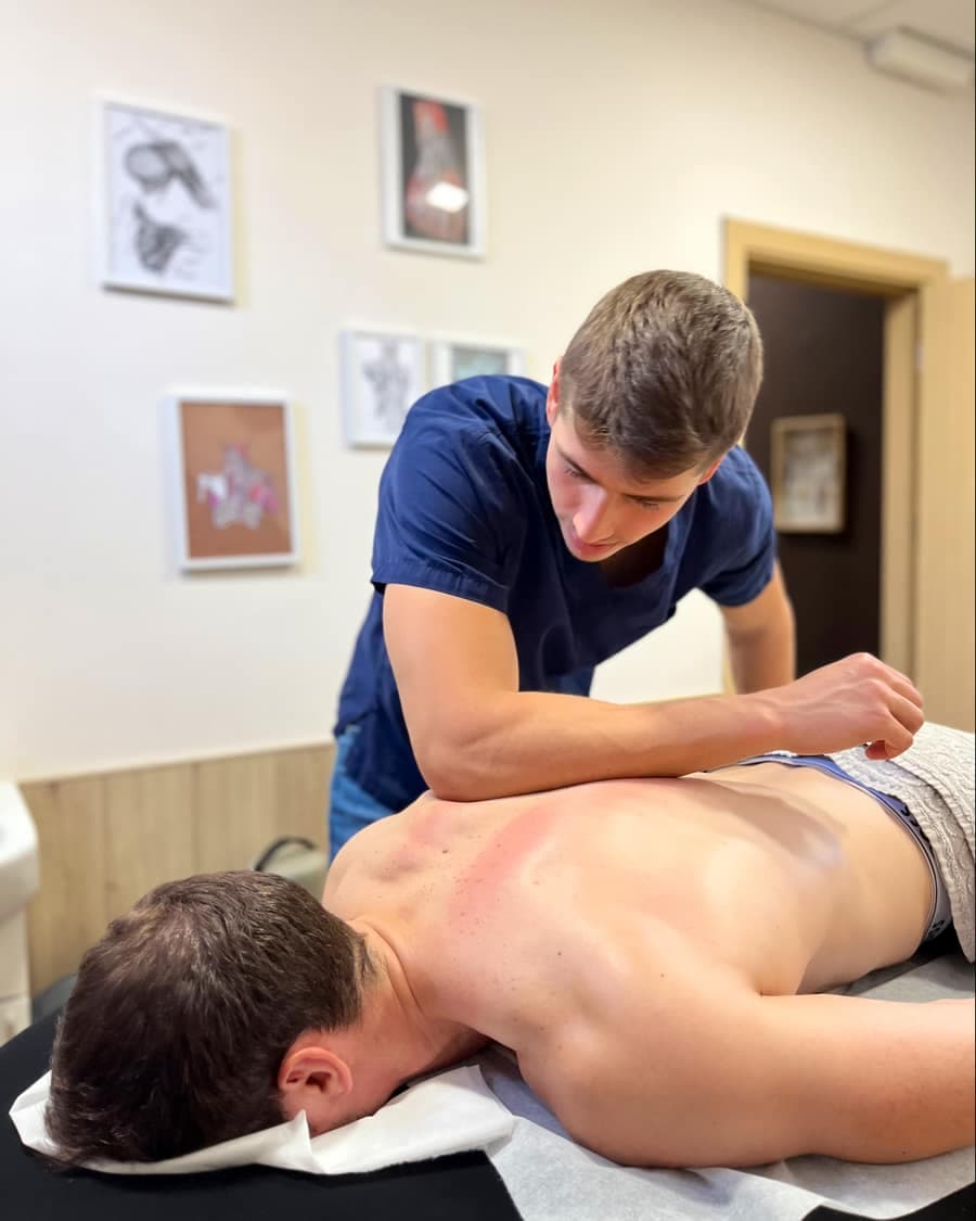 Терапевт извършва масаж на гърба на клиент в студио BodyFix